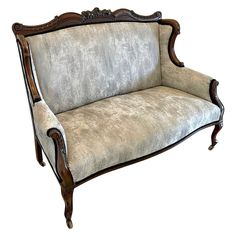 an antique style couch with wood trimming and upholstered fabric on the back