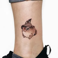 a small fish with a hat on it's head is sitting on the ankle