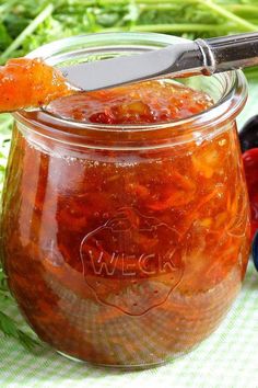 a jar filled with pickled carrots sitting on top of a green table cloth