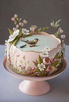 a decorated cake with flowers and birds on it