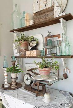 an old fashioned sewing machine is displayed on a table with potted plants and other items