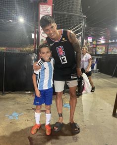 a man standing next to a little boy