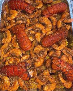 cooked lobsters and shrimp in a pan with seasoning on the side, ready to be served