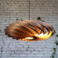 a wooden light fixture hanging from a brick wall