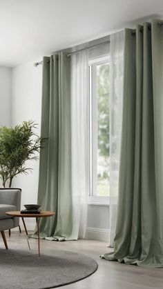 a living room with a couch, chair and window covered in green drapes next to a potted plant