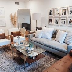 a living room with couches, chairs and pictures on the wall in it's center