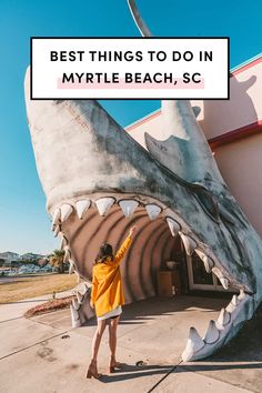 a woman standing in front of a giant shark statue with the words best things to do in my little beach, sc