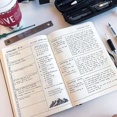 an open book sitting on top of a table next to a cup of coffee and other office supplies