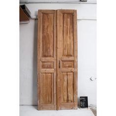 an old pair of wooden doors sitting on the side of a wall