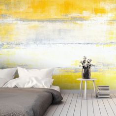 a bedroom with yellow and white paint on the wall, bedding and nightstands