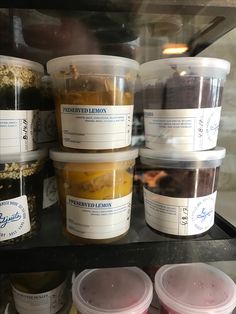 several plastic containers filled with different types of ice cream and toppings in a display case