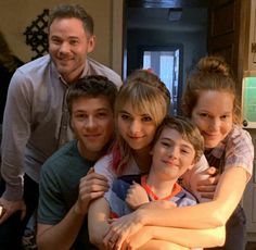 a group of people standing next to each other in front of a kitchen counter top