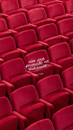 rows of red seats in an auditorium with spanish writing on the seat back and bottom