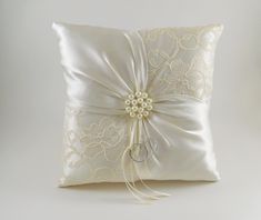 a white pillow with a bow on the front and ribbon at the back that is attached to it