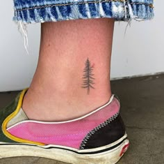 a small pine tree tattoo on the ankle