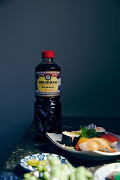 a bottle of ketchup sitting on top of a table next to plates of food