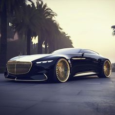 a black car with gold rims parked in front of palm trees