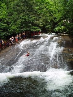 a group of people standing on the side of a waterfall