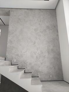 an empty room with concrete walls and stairs