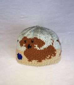 a brown and white knitted animal hat sitting on top of a snow covered ground