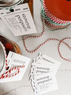 some red and white twine is next to two mason jars with labels on them