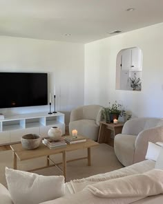 a living room filled with furniture and a flat screen tv mounted to the side of a wall