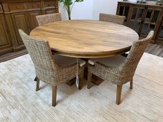 a round wooden table surrounded by wicker chairs