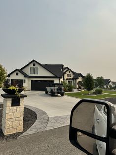 a car is parked in front of a house with a driveway and landscaping around it