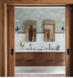 a bathroom with double sinks and two mirrors on the wall next to eachother