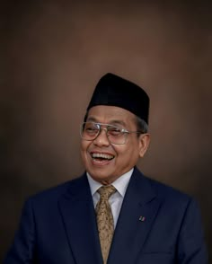 a man in a suit and tie smiling at the camera