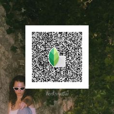 a woman sitting on the ground next to a tree with a qr code in front of her