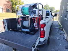 the back end of a white truck with an air hose in it's bed