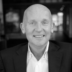 black and white photo of man in suit smiling