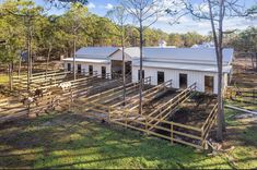 an aerial view of a farm house with horses in the yard and fenced in area