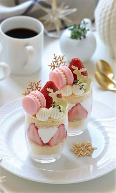 two desserts are sitting on a white plate with gold spoons next to it