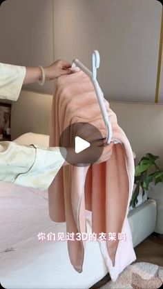 a woman is drying her clothes on the bed