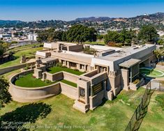 an aerial view of a large house in the middle of a park with lots of trees