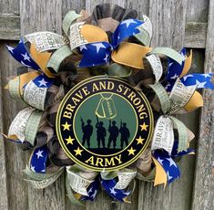 a wreath with the words brave and strong on it is attached to a wooden fence