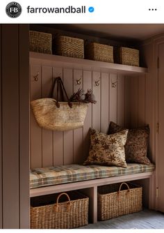 a wooden bench with baskets on top of it and two wicker baskets hanging from the wall