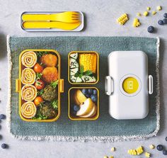 an overhead view of some food in containers with forks and spoons on the side