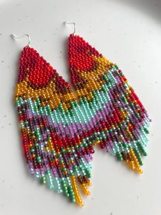 a pair of colorful beaded earrings sitting on top of a table