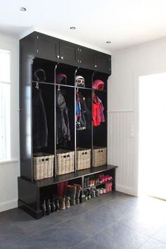 a black coat rack filled with coats and shoes