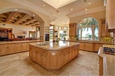 a large kitchen with an island in the middle and lots of windows on both sides