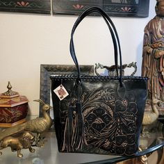 Art With Leather Black Handmade Tassled Floral Tooled Handbag. Measures Approximately 16" 12" Handles 12" Drop.Pre-Owned Brand New Never Used .Please See The Photos. Black Hand Tooled Tote Shoulder Bag, Black Hand Tooled Tote Bag, Black Hand Tooled Rectangular Shoulder Bag, Artisan Black Shoulder Bag, Black Hand Tooled Shoulder Bag For Everyday, Artisan Black Tote Shoulder Bag, Artisan Black Satchel Shoulder Bag, Artisan Black Leather Bag, Artisan Black Tote Bag