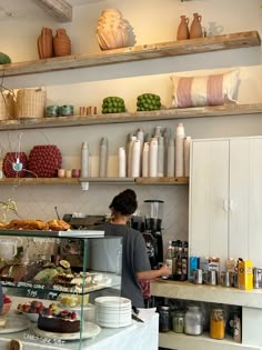 a woman standing in front of a counter filled with food