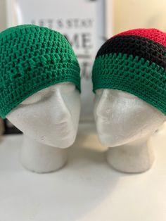 two knitted hats sitting on top of a white mannequin head