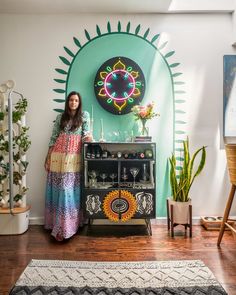 a woman standing in front of a colorful wall with an art work on the wall