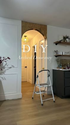 a ladder is in the middle of a room with white walls and wood flooring