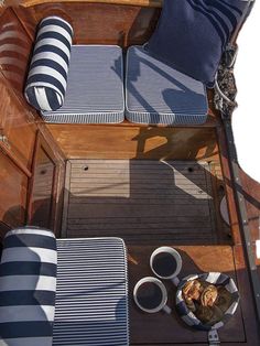 the interior of a boat with blue and white striped cushions on it's deck