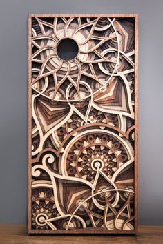 an intricately carved wooden box on a table with grey wall in the background and wood flooring